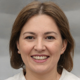 Joyful white adult female with medium  brown hair and brown eyes