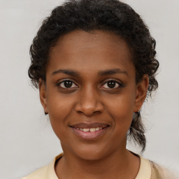 Joyful black young-adult female with medium  brown hair and brown eyes