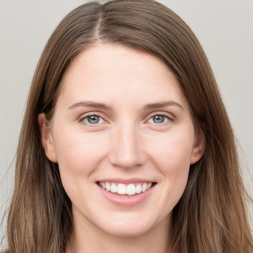 Joyful white young-adult female with long  brown hair and grey eyes