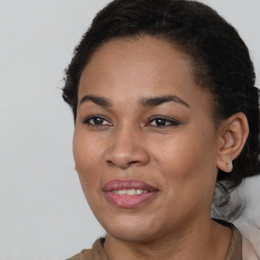 Joyful black young-adult female with short  brown hair and brown eyes