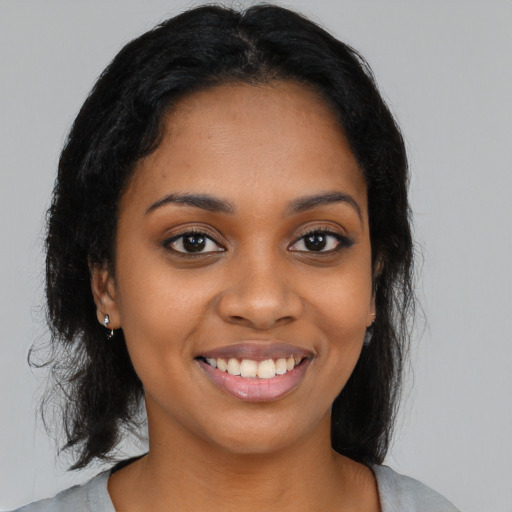 Joyful black young-adult female with medium  black hair and brown eyes