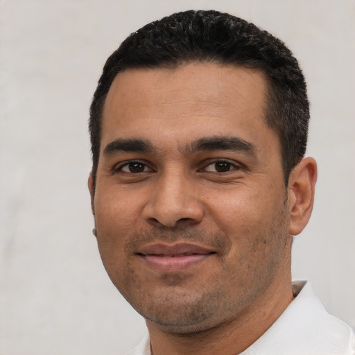 Joyful latino young-adult male with short  black hair and brown eyes