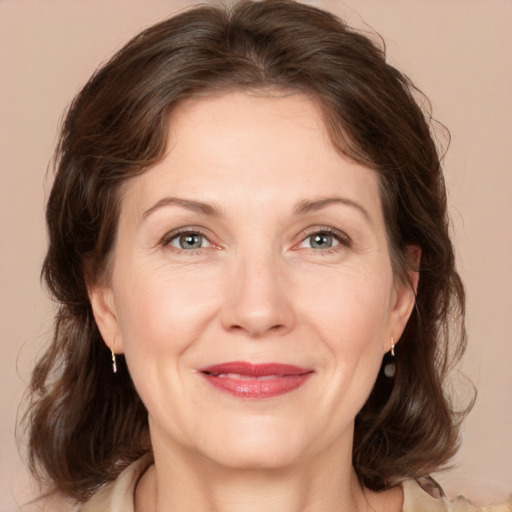 Joyful white adult female with medium  brown hair and grey eyes