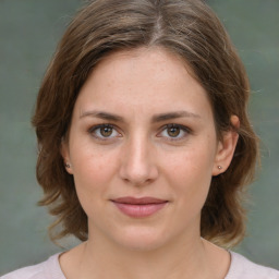 Joyful white young-adult female with medium  brown hair and green eyes