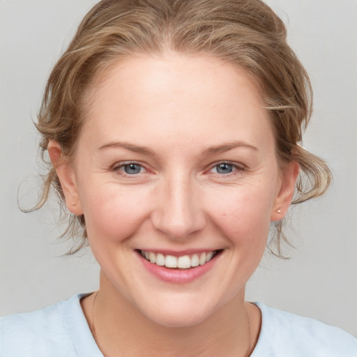 Joyful white young-adult female with medium  brown hair and blue eyes