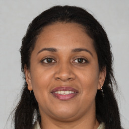 Joyful black adult female with long  brown hair and brown eyes