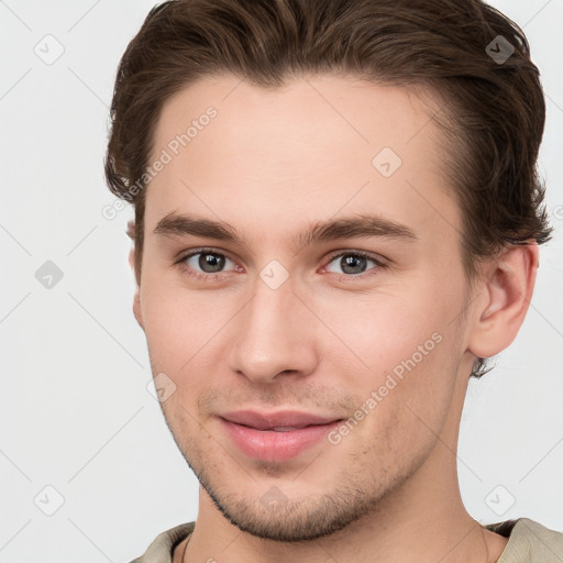 Joyful white young-adult male with short  brown hair and grey eyes