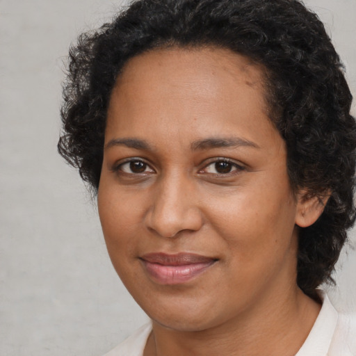 Joyful black young-adult female with medium  brown hair and brown eyes