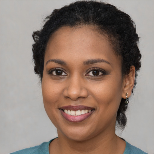 Joyful black young-adult female with short  brown hair and brown eyes