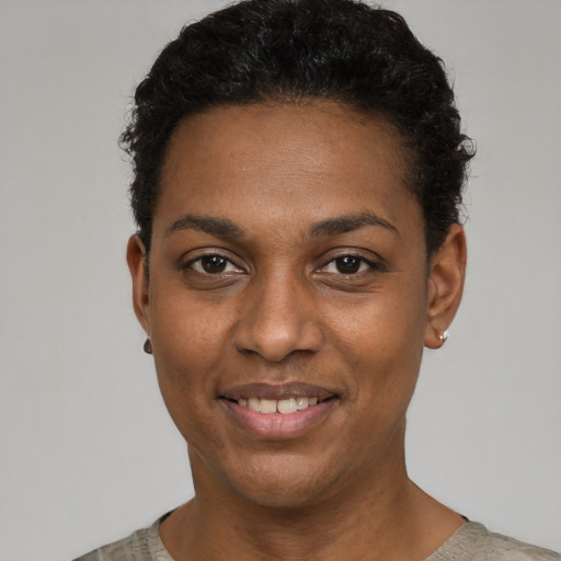 Joyful black young-adult female with short  black hair and brown eyes