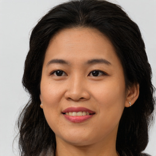 Joyful asian young-adult female with long  brown hair and brown eyes