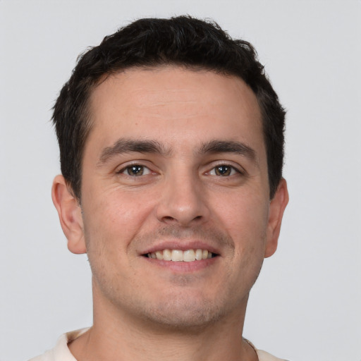 Joyful white young-adult male with short  brown hair and brown eyes