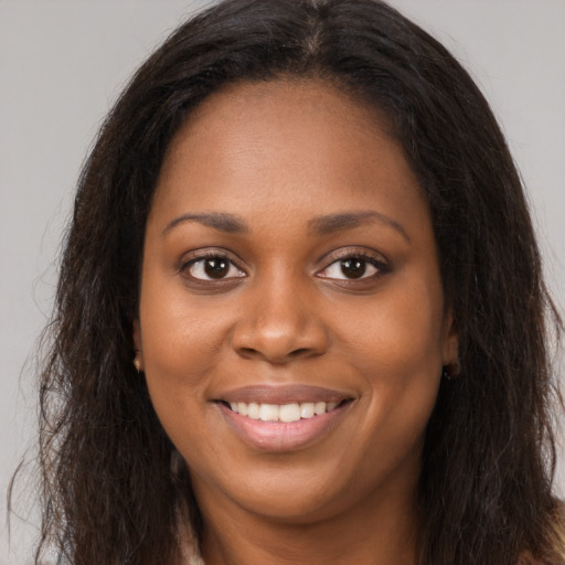 Joyful black young-adult female with long  brown hair and brown eyes
