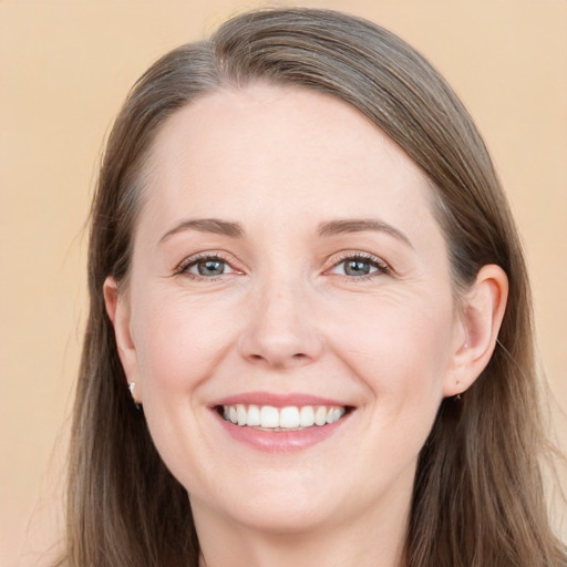 Joyful white young-adult female with long  brown hair and grey eyes