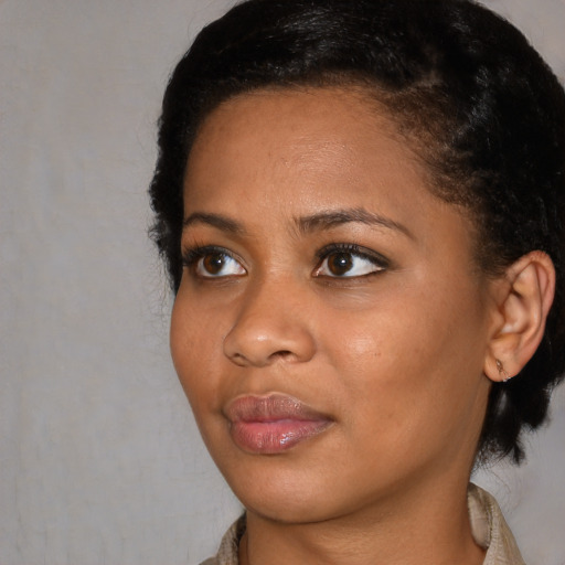 Joyful black young-adult female with short  black hair and brown eyes