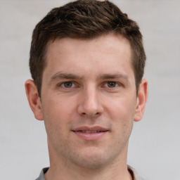 Joyful white young-adult male with short  brown hair and grey eyes