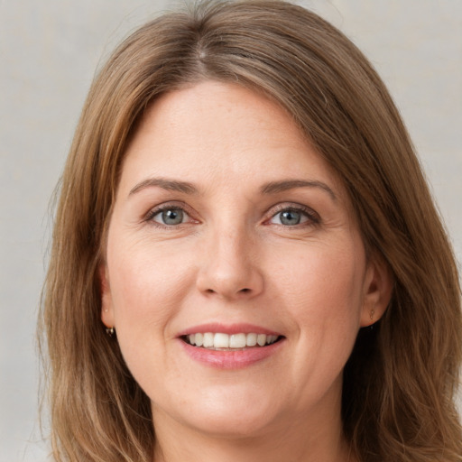 Joyful white young-adult female with long  brown hair and green eyes