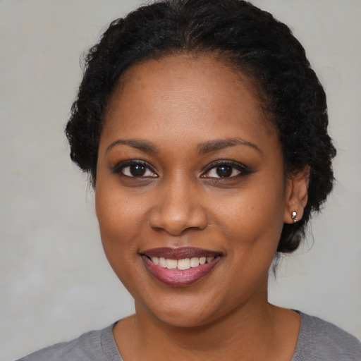 Joyful black young-adult female with short  brown hair and brown eyes