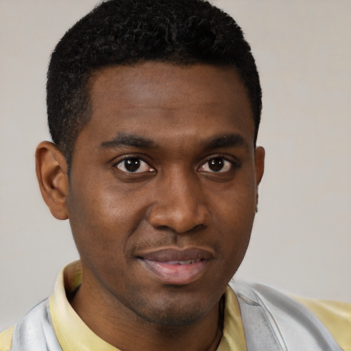 Joyful black young-adult male with short  brown hair and brown eyes