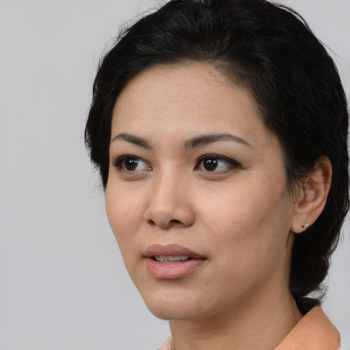 Joyful asian young-adult female with medium  black hair and brown eyes