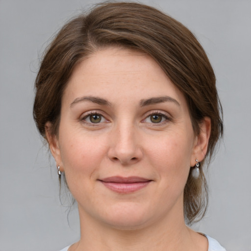 Joyful white young-adult female with medium  brown hair and green eyes