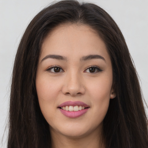 Joyful asian young-adult female with long  brown hair and brown eyes