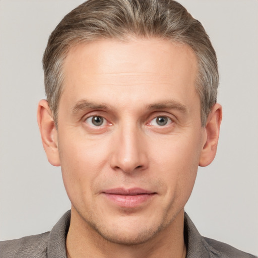 Joyful white adult male with short  brown hair and grey eyes