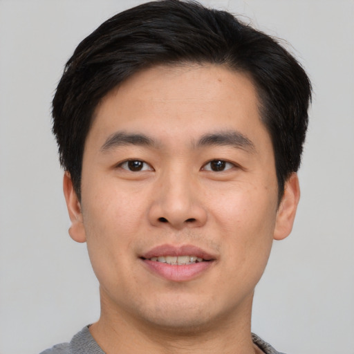 Joyful asian young-adult male with short  brown hair and brown eyes