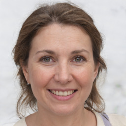 Joyful white adult female with medium  brown hair and grey eyes