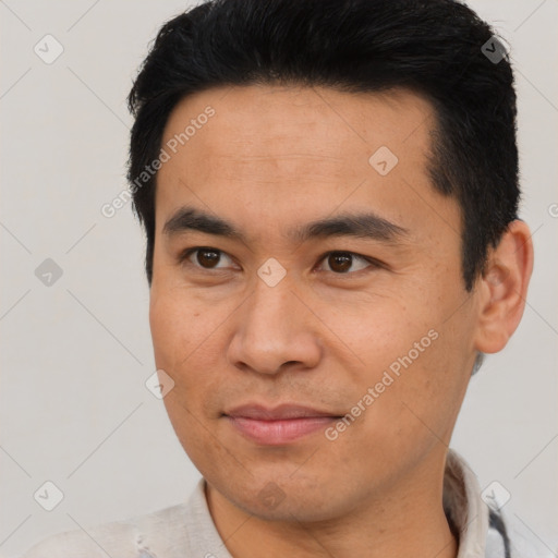 Joyful asian young-adult male with short  brown hair and brown eyes