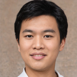 Joyful asian young-adult male with short  black hair and brown eyes