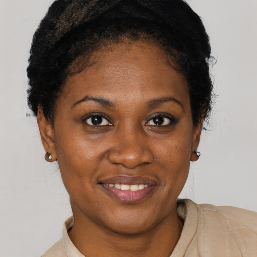 Joyful black young-adult female with short  black hair and brown eyes