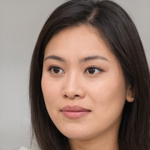 Joyful asian young-adult female with long  brown hair and brown eyes
