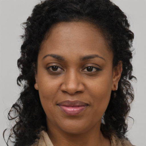 Joyful black adult female with long  brown hair and brown eyes