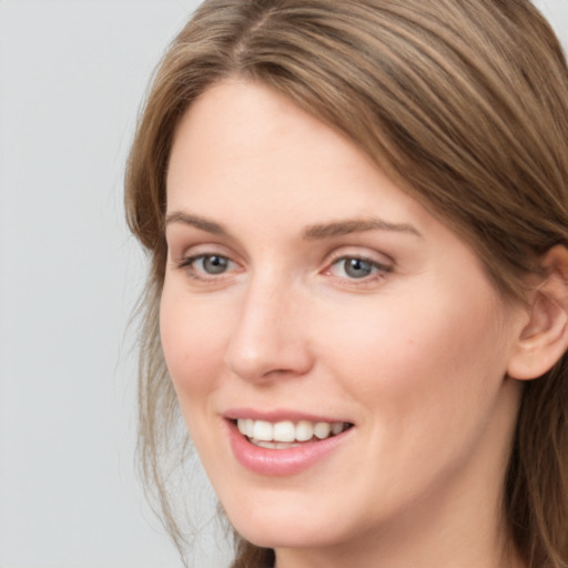 Joyful white young-adult female with long  brown hair and grey eyes