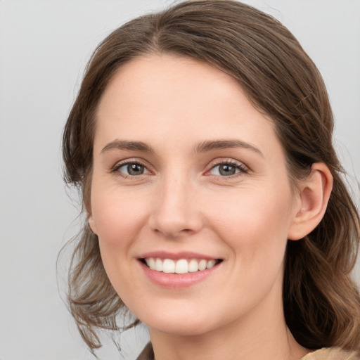 Joyful white young-adult female with medium  brown hair and grey eyes