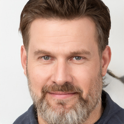 Joyful white adult male with short  brown hair and grey eyes