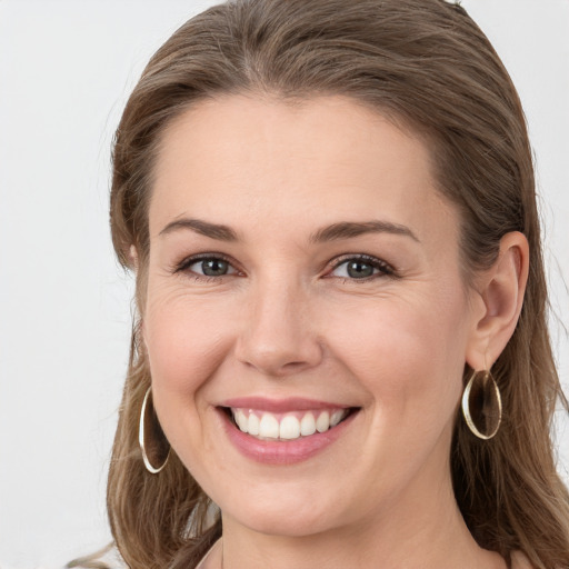 Joyful white young-adult female with long  brown hair and grey eyes