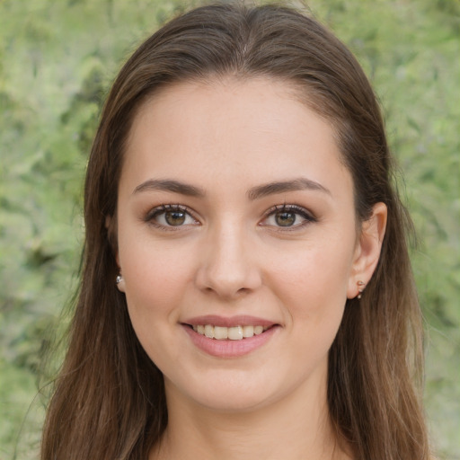 Joyful white young-adult female with long  brown hair and green eyes