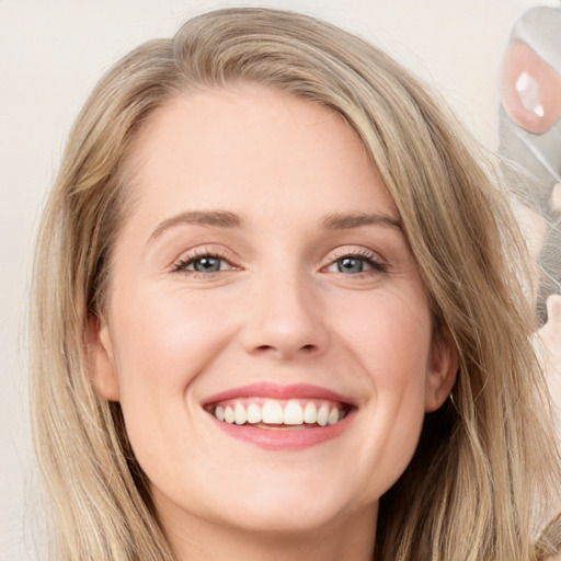 Joyful white young-adult female with long  brown hair and blue eyes