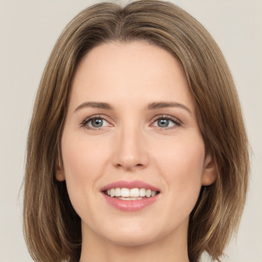 Joyful white young-adult female with medium  brown hair and green eyes