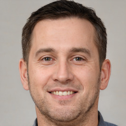 Joyful white adult male with short  brown hair and brown eyes