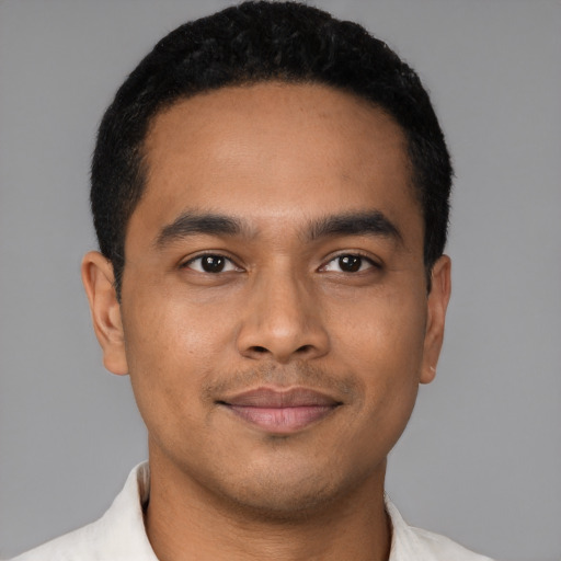 Joyful latino young-adult male with short  black hair and brown eyes