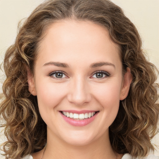 Joyful white young-adult female with long  brown hair and green eyes