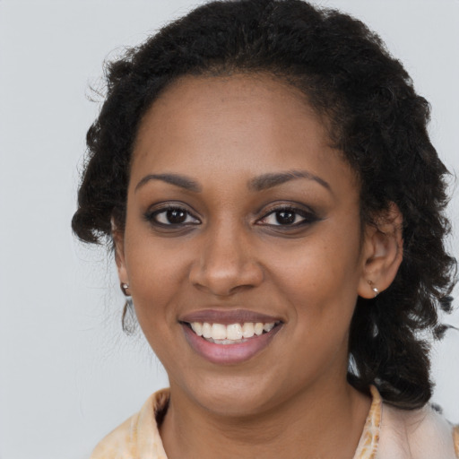 Joyful black young-adult female with long  brown hair and brown eyes
