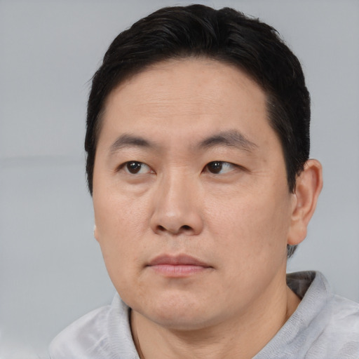 Neutral asian adult male with short  brown hair and brown eyes