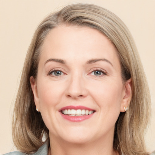 Joyful white adult female with medium  brown hair and grey eyes