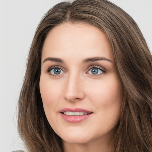 Joyful white young-adult female with long  brown hair and green eyes