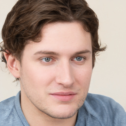 Joyful white young-adult male with short  brown hair and blue eyes