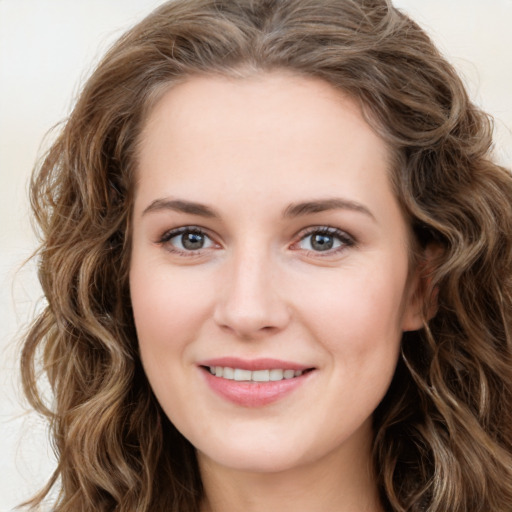 Joyful white young-adult female with long  brown hair and green eyes